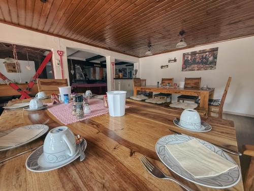 una sala da pranzo con tavolo in legno e stoviglie di Pension Schihütte a Oberstaufen