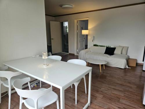 a living room with a white table and white chairs at Luna House in Gangneung