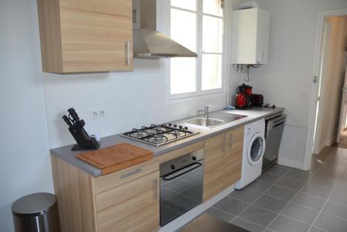 a kitchen with a stove top oven next to a sink at Appartement Chaussee du Sillon in Saint Malo