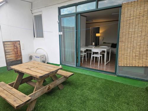 a picnic table and bench in a room with grass at Luna House in Gangneung