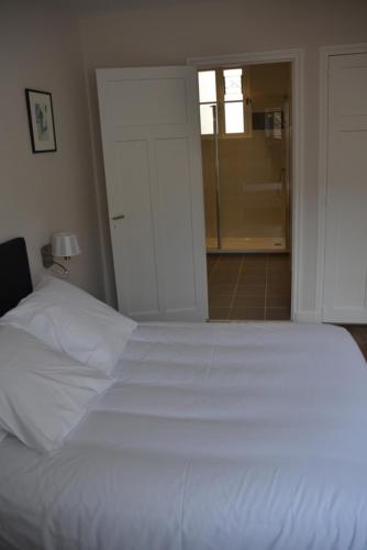 a bedroom with a white bed and a bathroom at Appartement Chaussee du Sillon in Saint Malo