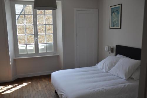 Appartement Chaussee du Sillon في سان مالو: غرفة نوم بسرير ابيض ونافذة