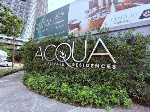 a sign for a building with bushes at Hotel Residences at ACQUA Tower near Rockwell Makati in Manila