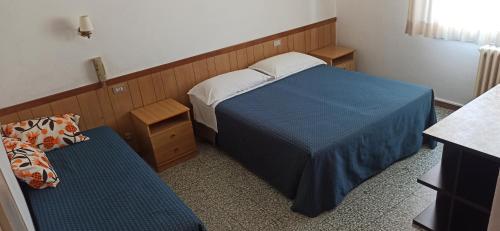 a small bedroom with a bed and a chair at Albergo Le Rose in Pistoia