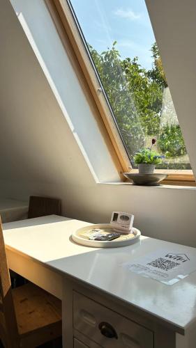 a window in a room with a table with a plate at Pannónia Rooms and Apartments in Satu Mare