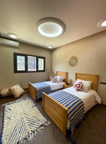 a bedroom with two beds and a rug at Shams Ourika in Sbiti