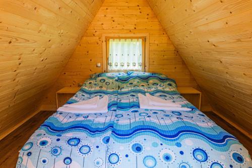 ゴレンスカ地方にあるGlamping Radovna pr' Klemenakの窓付きの木造キャビンのベッド1台分です。