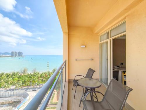 a balcony with a table and chairs and a view of the ocean at Shengyi Holiday Villa Hotel in Sanya