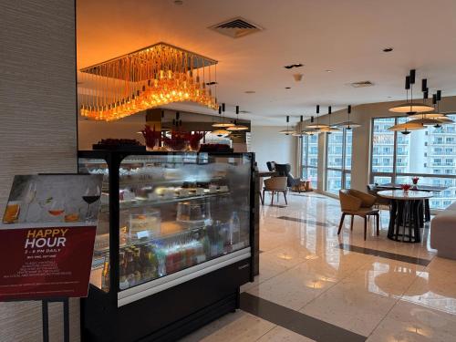 a restaurant with a happy hour display in a lobby at Hotel Residences at ACQUA Tower near Rockwell Makati in Manila