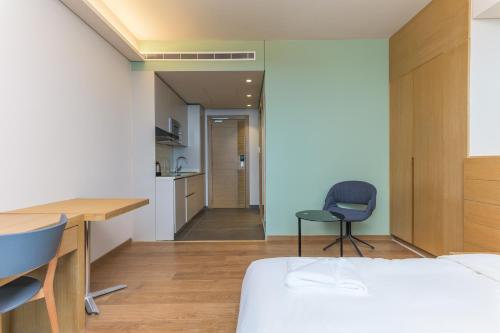 a bedroom with a bed and a desk and chairs at Jounieh Living - Residences by Local Host in Ed Dkârîne