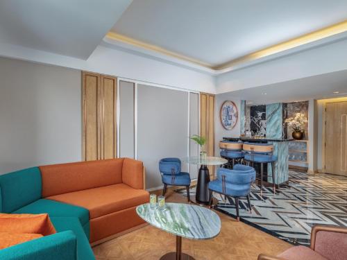 a living room with a couch and a table and chairs at Pipa Hotel Bangkok Sukhumvit 11 in Bangkok