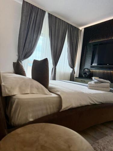 a bedroom with a large bed with a large window at RelaxMontan Apartment Sanpetru in Sînpetru