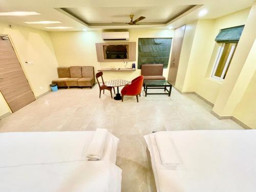 a room with two beds and a table and chairs at Near Sea Beach HOTEL RB-INN ! Puri,Near Jagannath Temple- Fully Air conditioned Rooms ,Wifi,- Lift and Restaurant, Parking Facilities - A Top Rated Hotel IN PURI in Puri