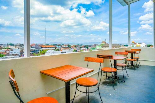 a row of tables and chairs on a balcony at Sans Hotel Nagari Malioboro in Yogyakarta