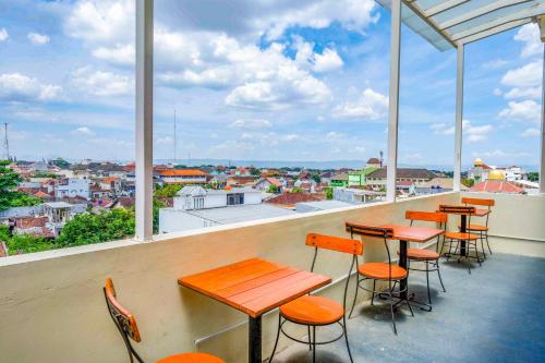 a row of tables and chairs on a balcony with a view at Sans Hotel Nagari Malioboro in Yogyakarta
