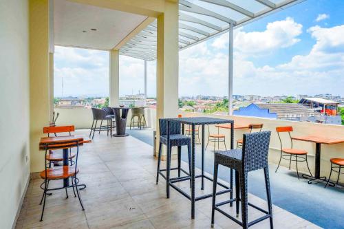a restaurant with tables and chairs on a balcony at Sans Hotel Nagari Malioboro in Yogyakarta