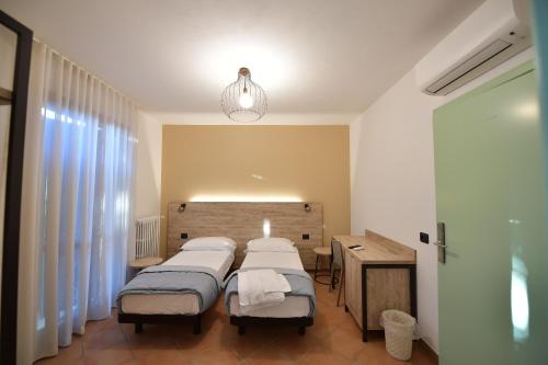 a hospital room with three beds and a desk at Hotel Vignale in Vignale