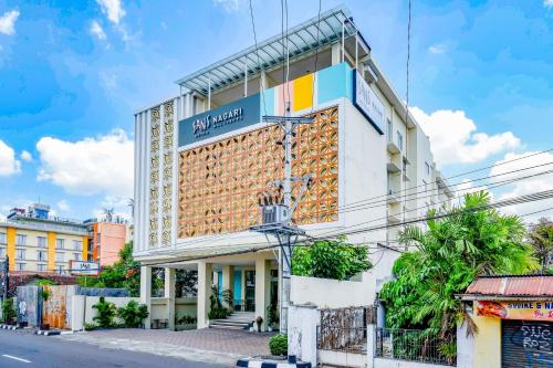 a building with a sign on the side of it at Sans Hotel Nagari Malioboro in Yogyakarta