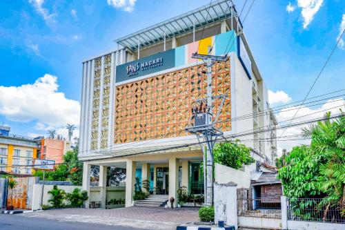 a building with a sign on the side of it at Sans Hotel Nagari Malioboro in Yogyakarta
