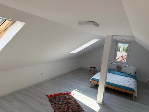 a attic bedroom with a bed and a window at Alex88 in Buşteni