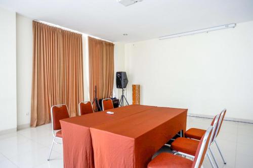 a conference room with a wooden table and chairs at Sans Hotel Nagari Malioboro in Yogyakarta