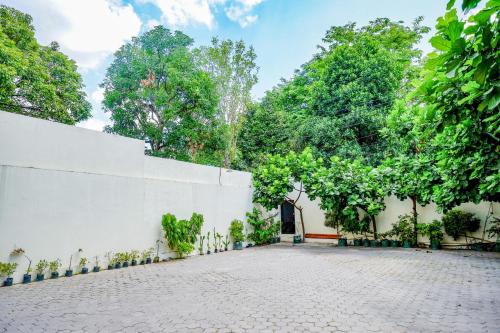 a white wall with trees in the background at Sans Hotel Nagari Malioboro in Yogyakarta