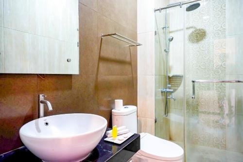 a bathroom with a sink and a toilet and a shower at Sans Hotel Nagari Malioboro in Yogyakarta