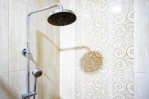 a shower with a shower head in a bathroom at Sans Hotel Nagari Malioboro in Yogyakarta