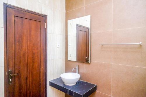 a bathroom with a sink and a mirror at Sans Hotel Nagari Malioboro in Yogyakarta