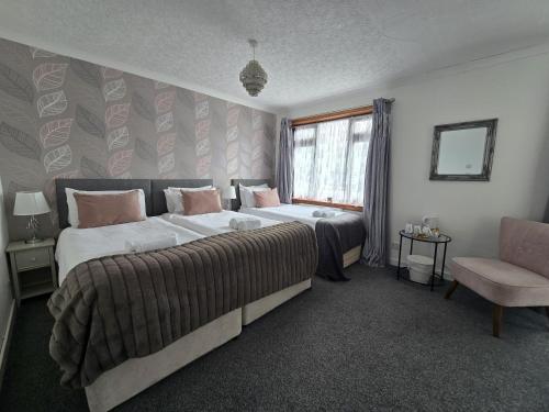 ウィグにあるSkye Accommodationのベッドルーム1室(ベッド2台、窓、椅子付)