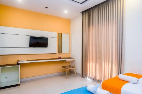 a hotel room with a bed and a desk at Sans Hotel Nagari Malioboro in Yogyakarta