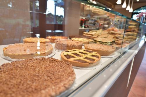 a display case in a bakery with cakes and pies at Hotel Vignale in Vignale