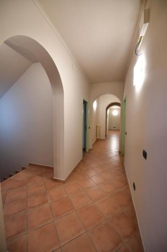 an empty hallway with a tile floor and an archway at Hotel Vignale in Vignale