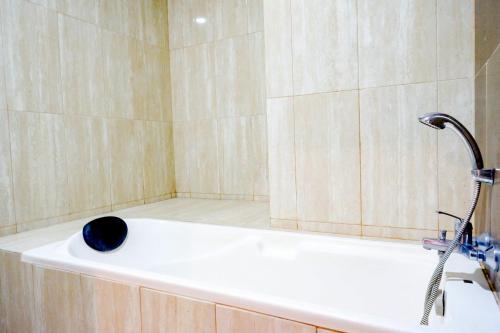 a bathroom with a shower with a black bowl on a tub at Sans Hotel Nagari Malioboro in Yogyakarta