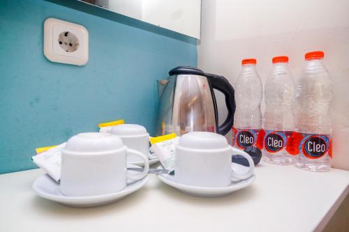 a counter with two cups and bottles of coke at Sans Hotel Nagari Malioboro in Yogyakarta