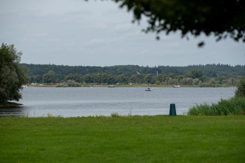 a view of a lake with a boat in the water at Kooparc vakantiepark in Giesbeek