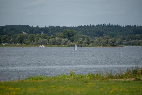 a sailboat in a large lake with a boat at Kooparc vakantiepark in Giesbeek