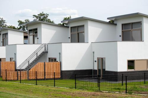 a white building with a fence in front of it at Kooparc vakantiepark in Giesbeek