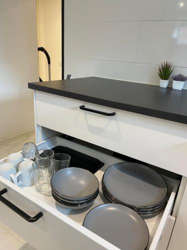 a kitchen with plates and dishes on a shelf at Mysiga lägenheten I Örebro in Örebro