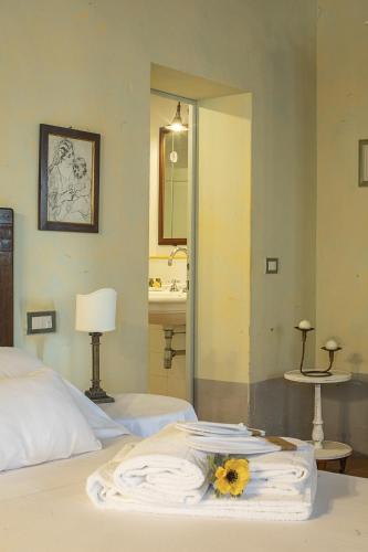 a bedroom with a bed with a flower on it at Cortona Resort-Le Terre Dei Cavalieri in Cortona
