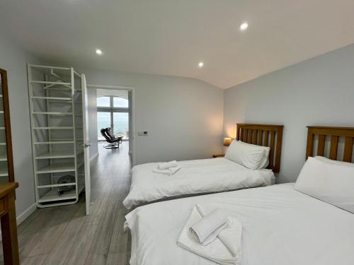 - une chambre avec 2 lits et un dressing dans l'établissement 15 Golden Bay Holiday Village - Coastal Retreat with Breathtaking Views, à Westward Ho