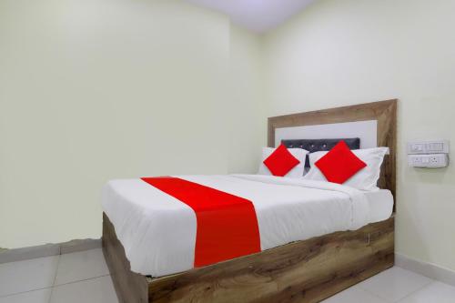 a bedroom with a bed with red and white pillows at HOTEL O SHAZEB INTERNATIONAL in Hyderabad
