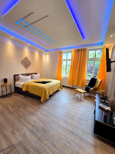 a bedroom with a bed and a couch and windows at Stilvoll zu Hause mit Charme, bis zu 7 Personen in Halberstadt
