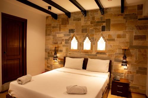 a bedroom with two beds and two windows at Nag Pukhu Guest House in Bhaktapur