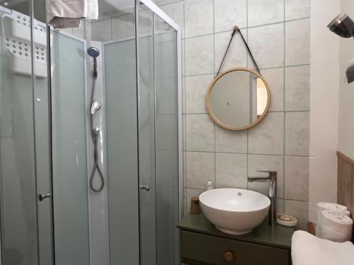 a bathroom with a shower and a sink and a mirror at La Pastorale in La Bâtie-Neuve