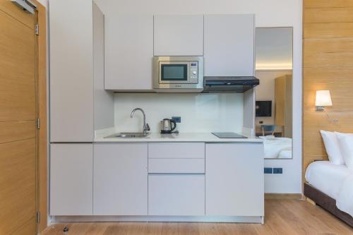 a kitchen with a microwave and a sink in a room at Jounieh Living - Residences by Local Host in Ed Dkârîne