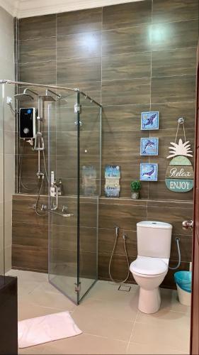 a bathroom with a toilet and a glass shower at Casa Tanjung Jara Villa in Kampong Gok Kapor