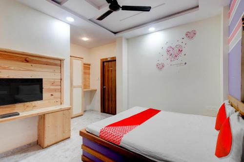 a bedroom with a bed and a flat screen tv at Hotel O Holiday Prime in Nagpur