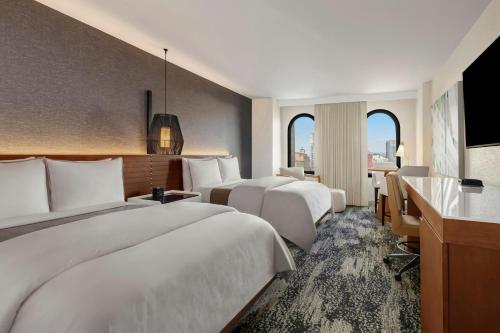 a hotel room with two beds and a desk at The Westin San Diego Gaslamp Quarter in San Diego