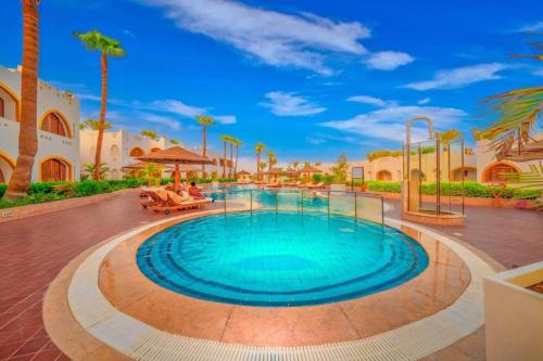 ein Swimmingpool in einem Resort mit Palmen in der Unterkunft Stanza Luna, Domina Coral Bay, Prestige hotel in Sharm El Sheikh